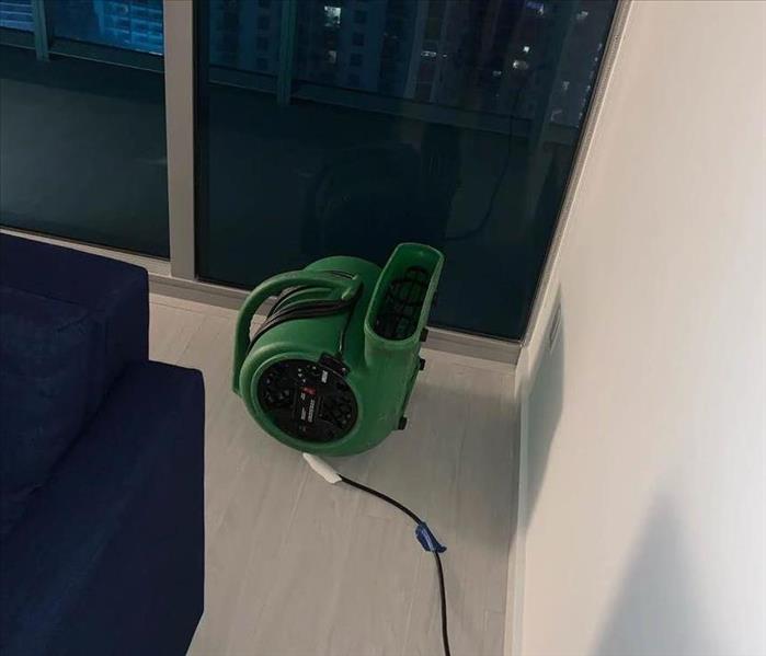 air mover placed in a corner to speed up the evaporation in a water damaged apartment